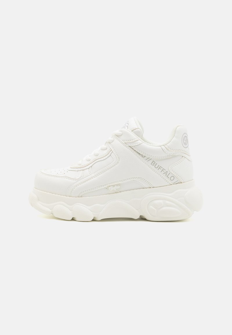 Baltas sporta apavi ar sintētiskas ādas augšdaļu, biezām, teksturētām zolēm, smalkiem šuvumiem un zīmola logo sānos.