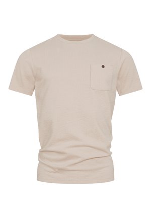 T-shirt beige texturé à manches courtes avec col rond et petite poche poitrine ornée d'un bouton foncé.