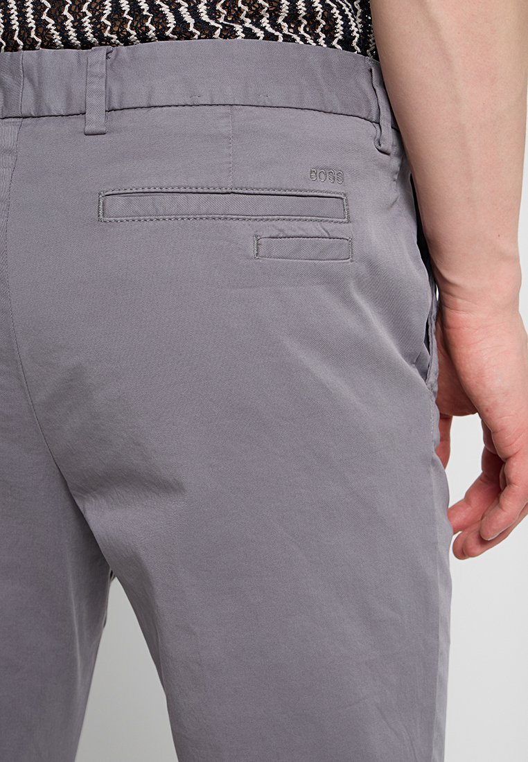 Szare lekkie spodnie o gładkiej fakturze, z dwoma tylnymi kieszeniami i wyszywanym logo marki "BOSS" na boku.