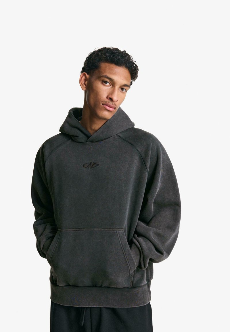 Dark gray hoodie with a large front pocket, drawstring hood, and ribbed cuffs. Features a subtle logo on the chest. Soft texture.