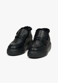 Černé kožené boty s tlustou platformou, vybavené chlupatým límcem a dvěma přezkami na svršku. Hladký povrch se strukturovanou podrážkou.