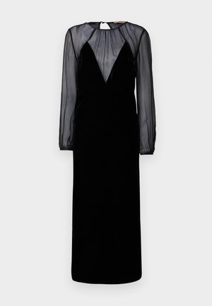 Melnas kleitas ar samtainu augšu un caurspīdīgām garām piedurknēm. Tam ir dziļa V veida kakla izgriezuma forma un plīšu detaļas plecu rajonā.