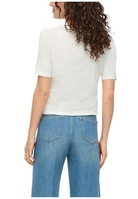 Witte T-shirt met korte mouwen en een ronde halslijn, gecombineerd met lichtblauwe hoge taille jeans met achterzakken en een rechte pijp.
