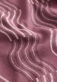 Tissu violet avec des lignes ondulées blanches et foncées formant un motif abstrait fluide sur une surface texturée.