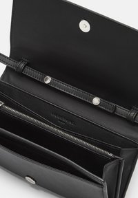 Czarny skórzany portfel z metalowymi zapięciami i zamkiem, z wieloma przegrodami i gładką fakturą. Wnętrze zawiera szczegóły identyfikacyjne marki.