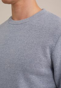 Hanorac bleu deschis, cu guler rotund cu nervuri. Textură de țesătură moale, cu un design simplu, fără modele sau embellishments suplimentare.
