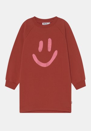 Rustfarvet langærmet skjortekjole med ribstrikkede manchetter og et stort lyserødt smilende ansigt grafik foran.