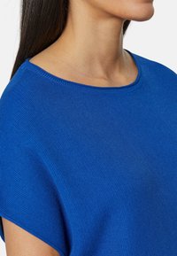 Niebieski dzianinowy top z okrągłym dekoltem i krótkimi rękawami, cechujący się gładką teksturą i luźnym krojem.