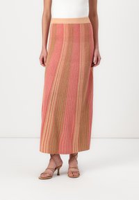 Jupe maxi à rayures verticales dans des nuances de rose et de beige, avec une texture côtelée et une taille élastique.