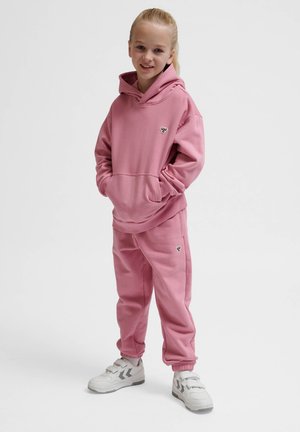 Roze hoodie en bijpassende joggingbroek van zachte stof. Hoody-ontwerp met känguruzak. Voorzien van logodetail op de borst. Witte sneakers.