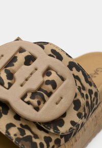 Σανδάλι με σχέδιο λεοπάρ, με μπεζ υφασμένη λωρίδα και μεγάλο πόρπη. Διαθέτει επενδυμένο πέλμα και σόλα από φελλό.