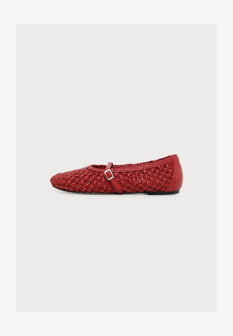 Chaussure plate tissée rouge avec une petite sangle à boucle et un talon lisse, présentée sur un fond clair uni.