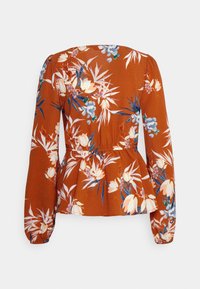 Blusa de cor ferrugem com padrão floral, de mangas longas, com cintura peplum e textura suave. Apresenta grandes flores brancas e azuis com realces verdes.