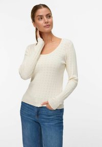 Witte ribbeltrui met een ronde halslijn, lange mouwen en textuurdetails. Gecombineerd met blauwe spijkerbroeken, heeft een lichte stretch.