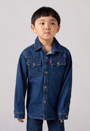 Camicia in denim blu con bottoni, due tasche sul petto, cuciture a contrasto e bottoni a scatto. Maniche lunghe e design del collo classico.