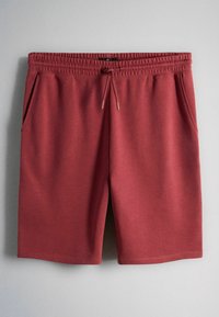 Bordeauxkleurige shorts met elastische taille, trekkoord en zijzakken, weergegeven tegen een grijze achtergrond.