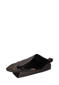 Borsa in tela nera con zip in cima, dotata di dettagli in pelle marrone e tasche interne. Texture morbida; progettata per un utilizzo pratico.