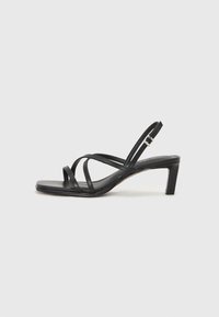 Black strappy sandal with a square toe and a low block heel. Features multiple thin straps and an adjustable ankle strap. Made of smooth leather.