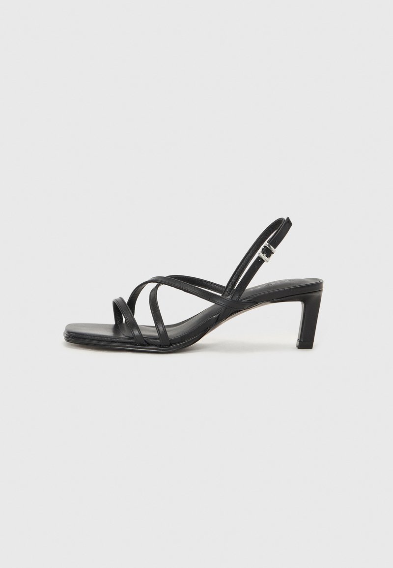 Black strappy sandal with a square toe and a low block heel. Features multiple thin straps and an adjustable ankle strap. Made of smooth leather.