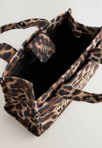 Sac en tissu imprimé léopard avec deux poignées, fermeture à bouton magnétique et intérieur noir. Présente un détail de logo doré sur un côté.