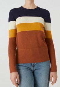 Randig tröja i marinblått, krämfärgat, senapsgult och rostfärgat. Tillverkad av mjukt material med rund hals och åtsittande ärmar.