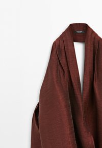 Brązowa marynarka z otwartym kołnierzem szalowym wykonana z miękkiej, fakturowanej tkaniny na białym tle, metka z napisem Massimo Dutti.