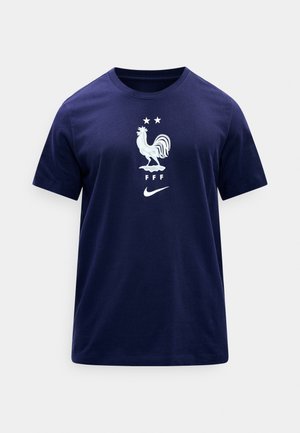 Marineblå T-shirt med korte ærmer med hvidt hanebjælkemblem, to stjerner, bogstaverne "FFF" og Nike swoosh-logo placeret midt på brystet.