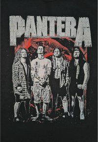 Černé tričko s potiskem čtyř členů kapely s dlouhými vlasy. Design zahrnuje text "PANTERA" v tučných, opotřebovaných bílých písmenech.