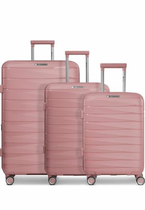 Tre valigie rigide rosa con scanalature orizzontali, manici estensibili e quattro ruote girevoli, disposte dalla più grande alla più piccola.