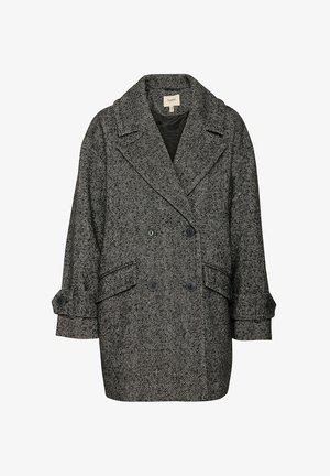 Melnā un baltā zāģēta divrindu mētelis ar lielām atloks, sānu kabatām un pogājamiem piedurknēm.