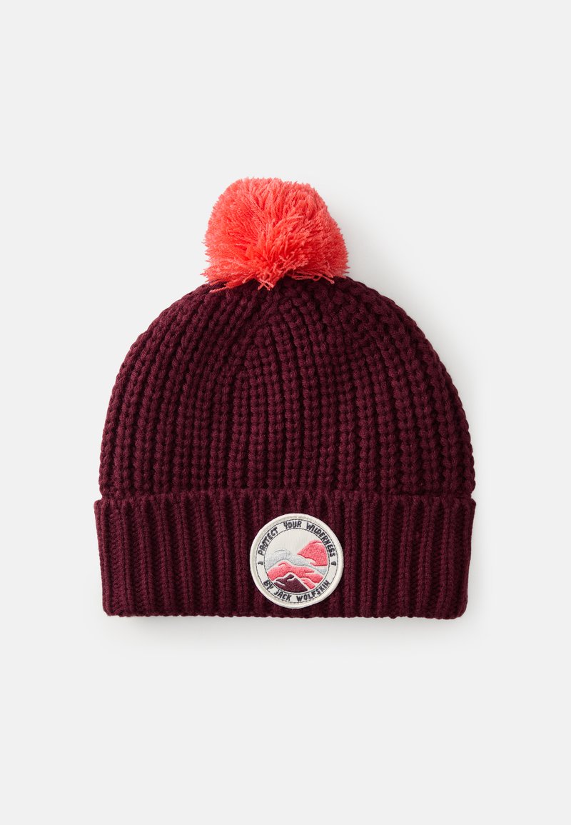 Un bonnet en maille bordeaux avec un design côtelé, orné d'un pompon orange vif et d'un patch circulaire représentant des graphiques de montagne.