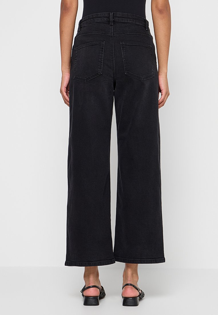 Zwarte denim jeans met wijde pijpen en een hoge taille, voorzien van twee achterzakken, zichtbare stiksels en een nette zoomafwerking.