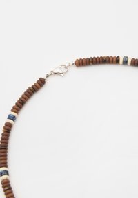 Träbeads-halsband med runda bruna pärlor, accentuerat med krämfärgad och blå pärlor, avslutat med en silverfärgad kräftklämma.