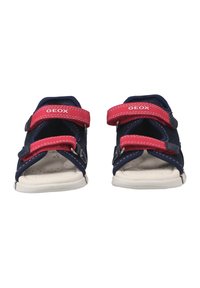Sandalias GeoX en azul y rojo con dos tiras ajustables de velcro, diseño de punta abierta, plantilla acolchada y suela de goma blanca.