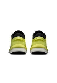Two rear-facing athletic sneakers in bright yellow with black accents, featuring a textured surface and a cushioned white sole.