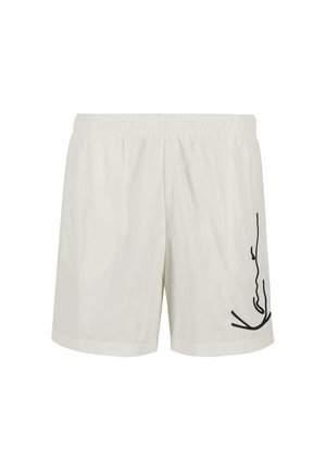 Cremfarbene Badeshorts mit elastischem Bund, ausgestattet mit einem abstrakten schwarzen Linienstich auf der linken Seite. Leichtes und schnell trocknendes Material.