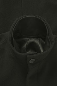 Must villane mantel kõrge kraega, sileda satiinvoodriga ja ühe nupuga kinnitusega krae lähedal.