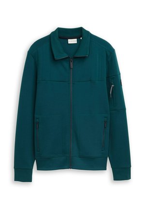Veste zippée couleur sarcelle avec col et poignets côtelés, deux poches avant zippées et une poche zippée sur la manche gauche.