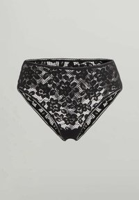 Svart spets högmidjad damunderkläder med blommönster och scallopkanter på en enfärgad ljus bakgrund.