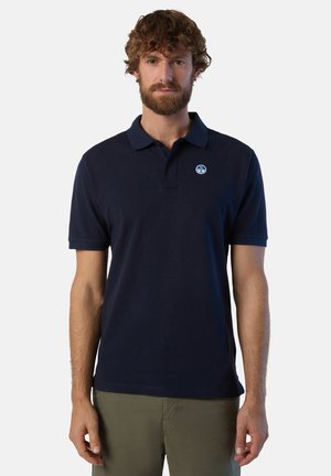 Polo shirt blu navy in cotone, con colletto ed un emblema sul lato sinistro del petto. Maniche corte e design a vestibilità standard.