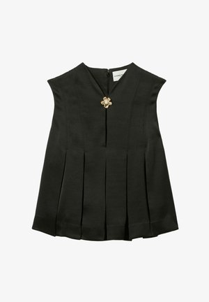 Top sans manches noir avec un décolleté en V et un design plissé. Présente un accent décoratif en forme de fleur dorée près du centre et une fermeture éclair dans le dos.
