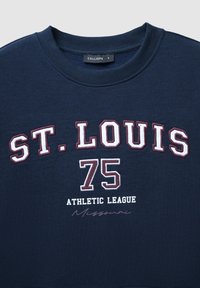 Sweatshirt bleu marine avec un col rond. Présente un texte blanc et bordeaux indiquant "ST. LOUIS 75 ATHLETIC LEAGUE Missouri" dans différentes polices.