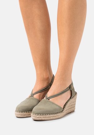 Green suede wedge sandals with crisscross straps and jute-wrapped wedge heel. Smooth texture and stitched detailing along the sole.