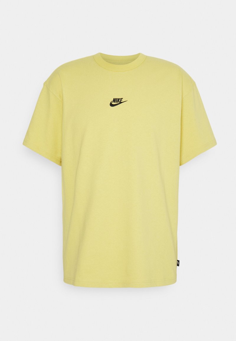 Gul bomulds T-shirt med rund hals og korte ærmer. Har en lille sort Nike-logo på brystet. Glat tekstur, løs pasform.
