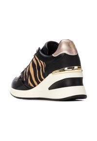 Zapatillas deportivas con cuña en negro y beige, con un diseño de rayas de tigre, acentos metálicos y material texturizado en negro en el talón y los laterales.