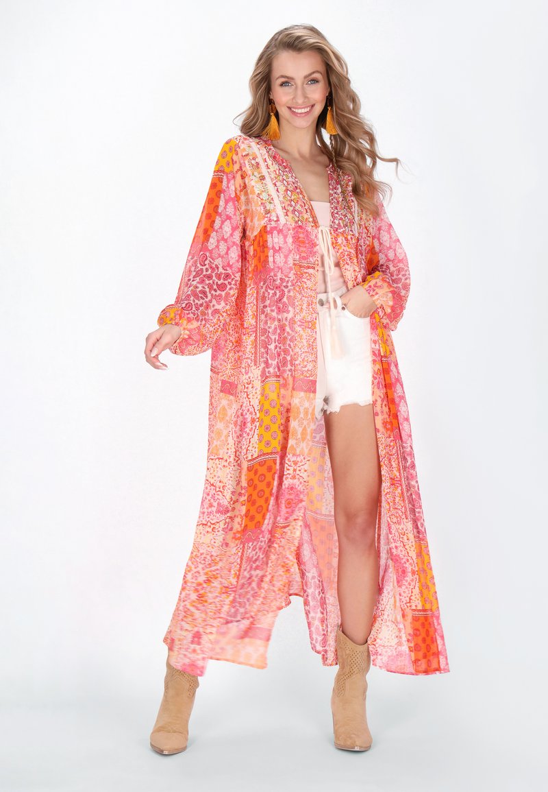 Kimono lungo e trasparente in vivaci modelli a patchwork rosa, arancione e giallo, con maniche ampie e chiusura a cravatta in vita.