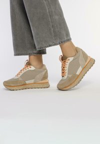 Baskets de sport beiges en maille, suède et cuir ; lacets orange ; semelle texturée ; design léger ; col rembourré.