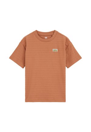 Camicia a maniche corte color arancio bruciato, con motivo testurizzato, scollo rotondo e una piccola etichetta "PUERTO MONTAÑA" sul petto sinistro.