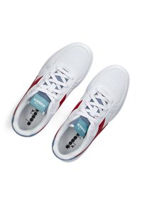 Witte sportieve schoenen met rode accenten, geperforeerde bovenkant voor ademend vermogen, en blauwe details op de tong. Vetersluiting, platte zool.