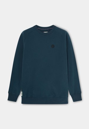 Sudadera azul marino con cuello redondo, mangas raglán y puños de canalé. Presenta un pequeño logotipo circular negro en el pecho. Textura suave.
